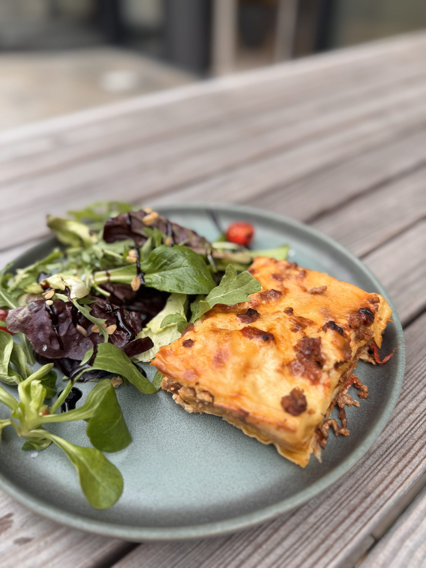 Lasagna with fresh salad on terrace